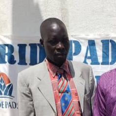 Two men standing in front of a Pridepad Africa banner.